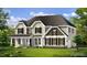 Inviting two-story home shows off a covered porch, black shuttered windows, and beautiful landscaping at 315 Adams Pointe Ct, Angier, NC 27501