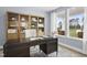 A well-lit home office featuring a dark wooden desk, built-in shelving, and a window view at 315 Adams Pointe Ct, Angier, NC 27501