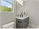 Stylish bathroom with quartz counters, a dark vanity, modern fixtures and a bright window at 3221 Skycrest Dr, Raleigh, NC 27604