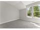 Sun-filled bedroom with trees visible through the windows and plush carpet at 3221 Skycrest Dr, Raleigh, NC 27604