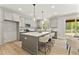 Bright kitchen with an island, quartz countertops, stainless appliances and modern pendant lights at 3221 Skycrest Dr, Raleigh, NC 27604
