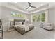 Spacious main bedroom with tray ceiling, fan, and large windows overlooking the scenic outdoors at 3221 Skycrest Dr, Raleigh, NC 27604