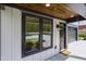 Inviting porch with wood ceiling, modern door, and windows at 3221 Skycrest Dr, Raleigh, NC 27604