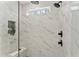 Luxurious shower with marble tile, dual showerheads, a niche, and a bench for the ultimate spa experience at 3221 Skycrest Dr, Raleigh, NC 27604