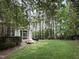Spacious backyard with lush greenery, a brick patio, and mature trees providing shade at 3300 Magical Pl, Raleigh, NC 27614