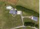 Aerial view of property with a pool, large lawn, outbuildings, and mature trees creating a private oasis at 3646 Watkins Farm Rd, Hillsborough, NC 27278