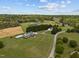 Aerial view showcases the expansive property with multiple buildings, lush lawns, and mature trees at 3646 Watkins Farm Rd, Hillsborough, NC 27278
