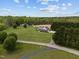 An expansive estate with a traditional-style home, detached garage, and picturesque grounds from above at 3646 Watkins Farm Rd, Hillsborough, NC 27278
