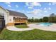 Landscaped yard with a refreshing pool, patio, deck, and grassy lawn, all fenced for privacy at 3646 Watkins Farm Rd, Hillsborough, NC 27278