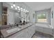 Elegant bathroom features double sinks, a granite countertop, a soaking tub, and a large window for natural light at 3646 Watkins Farm Rd, Hillsborough, NC 27278