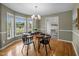 Open concept dining area shows hardwood floors and a bay window, adjacent to the open doorway into the living space at 3646 Watkins Farm Rd, Hillsborough, NC 27278