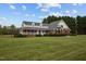 Beautiful home exterior with brick, white siding, a covered porch, and a spacious front yard at 3646 Watkins Farm Rd, Hillsborough, NC 27278