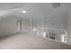 Bright loft featuring neutral carpet and a white railing overlooking the living room at 3646 Watkins Farm Rd, Hillsborough, NC 27278