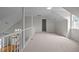 Spacious loft featuring neutral carpet and a white railing overlooking the staircase and living room at 3646 Watkins Farm Rd, Hillsborough, NC 27278