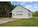 Side view of outbuilding with a garage door, door and side carport at 3646 Watkins Farm Rd, Hillsborough, NC 27278