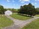 Exterior of outbuilding, featuring a white facade, garage door, and concrete driveway at 3646 Watkins Farm Rd, Hillsborough, NC 27278
