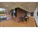 Inviting covered porch with brick and wood accents and outdoor seating at 3646 Watkins Farm Rd, Hillsborough, NC 27278