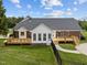 Rear exterior view of the home featuring an expansive wooden deck and walkway with black fencing at 3646 Watkins Farm Rd, Hillsborough, NC 27278