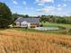 Stunning exterior view with in-ground pool, wooden deck, and fenced yard on a manicured lawn at 3646 Watkins Farm Rd, Hillsborough, NC 27278
