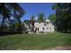 Backyard with table and chairs, and a well maintained yard with large shade trees at 3813 W West Lake Rd, Apex, NC 27539