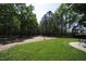 Secluded backyard with gravel path and green grass surrounded by mature trees at 3813 W West Lake Rd, Apex, NC 27539