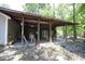 Back patio area with covered roof and chairs overlooking a natural, wooded area at 3813 W West Lake Rd, Apex, NC 27539