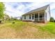Backyard with fire pit featuring a well-maintained lawn, fenced perimeter, and screened-in porch at 408 Price Lake Way, Fuquay Varina, NC 27526