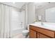 Well-lit bathroom features a wood vanity with a white sink and a shower-tub combination at 408 Price Lake Way, Fuquay Varina, NC 27526