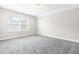 Bright, empty bedroom with plush carpeting, large window, and neutral decor for versatile styling at 408 Price Lake Way, Fuquay Varina, NC 27526
