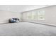 Spacious living area with neutral carpeting, featuring large windows that offer plenty of natural light at 408 Price Lake Way, Fuquay Varina, NC 27526