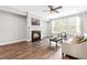 Bright living room featuring a fireplace, hardwood floors, and large windows with natural light at 408 Price Lake Way, Fuquay Varina, NC 27526