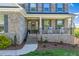 Inviting front porch with brick accents, seating, and beautiful curb appeal at 4424 Bonnie Loch Dr, Burlington, NC 27215