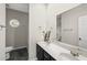 Bathroom featuring double sinks with a modern vanity, large mirror, and a view of the backyard at 50 Beech Trl, Garner, NC 27529