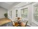 Bright breakfast nook features a glass table, seating for four, and views of the natural surroundings through the windows at 50 Beech Trl, Garner, NC 27529