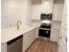 Modern kitchen featuring quartz countertops, stainless steel appliances, and white cabinetry at 512 Eastwood St, Durham, NC 27704