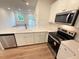 Stylish kitchen with quartz countertops, a stainless steel dishwasher, and modern fixtures at 512 Eastwood St, Durham, NC 27704