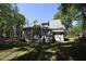 Back exterior view of home with backyard trees and a porch at 5200 Lorbacher Rd, Apex, NC 27539