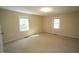 Spacious, carpeted bedroom featuring neutral walls and natural light from two windows at 5200 Lorbacher Rd, Apex, NC 27539