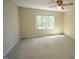 Cozy carpeted bedroom featuring a ceiling fan and natural light from a window at 5200 Lorbacher Rd, Apex, NC 27539