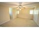 Comfortable carpeted bedroom with ceiling fan, closet, and natural light from windows at 5200 Lorbacher Rd, Apex, NC 27539