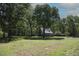 Peaceful home nestled among mature trees, offering plenty of outdoor space for recreation at 5200 Lorbacher Rd, Apex, NC 27539
