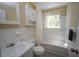 Cozy bathroom featuring a shower-tub combination, vanity with sink, and ample lighting at 5202 Lorbacher Rd, Apex, NC 27539