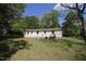 Rear view of the home showcasing a cozy backyard with lawn and access stairs at 5202 Lorbacher Rd, Apex, NC 27539