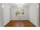 Well-lit dining area features hardwood floors, a chandelier, and views of the outdoor greenery at 611 Beaver Dam Rd, Raleigh, NC 27607