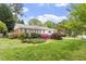 Attractive home with brick and white siding, accented by beautiful flowering bushes and a well-maintained lawn at 611 Beaver Dam Rd, Raleigh, NC 27607