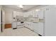 Well-lit kitchen with white cabinets, appliances and tile floor, offering a clean and functional space at 611 Beaver Dam Rd, Raleigh, NC 27607