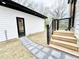 Backyard with a paved stone walkway to backyard steps of this modern home with white vinyl siding at 622 Glascock St, Raleigh, NC 27604