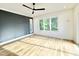Bright bedroom with hardwood floors, a ceiling fan, and large windows showcasing lush greenery at 622 Glascock St, Raleigh, NC 27604