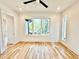 Bedroom with hardwood floors, white walls, ceiling fan, recessed lights, and large window with yard view at 622 Glascock St, Raleigh, NC 27604