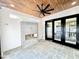 Outdoor covered porch with a modern fireplace, ceiling fan, and stone tile flooring at 622 Glascock St, Raleigh, NC 27604